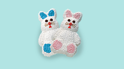 Two knitted bunny toys with pink ears and blue noses and eyes against a light blue background.