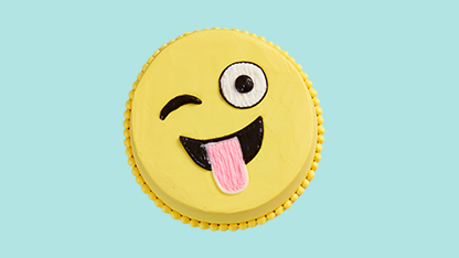 Smiley face cookie decorated with frosting and a face.