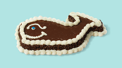 Cake decorated like a whale. Blue and white frosting for water, brown frosting for body. Chocolate chips for eyes, tail and fins.